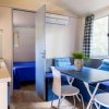 Interno di una casa mobile con zona pranzo, cucina e camera da letto, decorato con tocchi di blu.