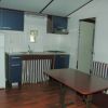 Una cucina con mobili blu, frigorifero bianco e tavolo in legno. Pavimenti in legno scuro.