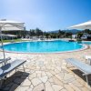 Piscina all'aperto con lettini e ombrelloni.