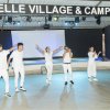 Persone sul palco che ballano, tutte vestite di bianco.