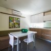 Interni di bungalow con tavolo, sedie e cucina.