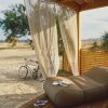 Patio con lettino, bici e tenda, vista sulla spiaggia.