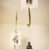 Scultura appesa di figura seduta con cartoline.