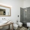 Bagno moderno con doccia, specchio grande e bidet.
