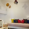 Stanza con divano e cuscini colorati, decorazioni sulle pareti.