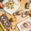 Tavola apparecchiata con piatti creativi, bicchieri di vino e acqua.