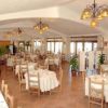 Un ristorante con tavoli apparecchiati, sedie in legno e lampade sospese.