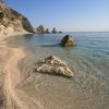 Spiaggia con rocce, acqua trasparente e scogliere.