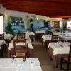 Interno di un ristorante elegante con tavoli apparecchiati e sedie in legno.