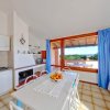 Cucina luminosa con tavolo, finestre e vista esterna.