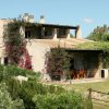 Casa in pietra con piante rampicanti e patio coperto.
