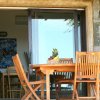 Tavolo e sedie in legno su un patio con porta a vetri.