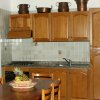 Cucina con mobili in legno e cesto di frutta sul tavolo.