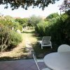 Giardino verde con lettino e tavolo bianco.