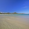 Spiaggia con sabbia chiara e mare trasparente.