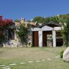 Facciata di una casa in pietra con fiori e prato.