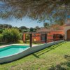 Piscina in giardino con casa arancione.