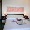 Camera d'albergo con letto matrimoniale, decorazioni floreali e un vassoio.