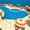 Piscina con piattaforme rotonde e ombrelloni arancioni, affacciata sul mare.