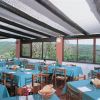 Sala da pranzo con tavoli apparecchiati e vista panoramica sulle colline.