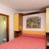 Stanza con letto matrimoniale, mobili gialli e quadro.