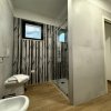 Bagno con doccia e piastrelle grigie.